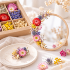 Idées de loisirs créatifs avec des têtes de fleurs séchées multicolores : miroir rond décoré de fleurs et petite broche fleurie, à côté d'un coffret Terralya.