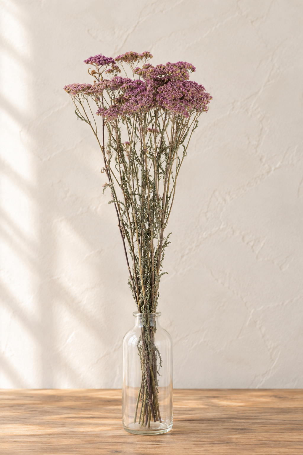 Achillée violette séchée bio française présentée dans un vase en verre sur une table en bois clair – Terralya