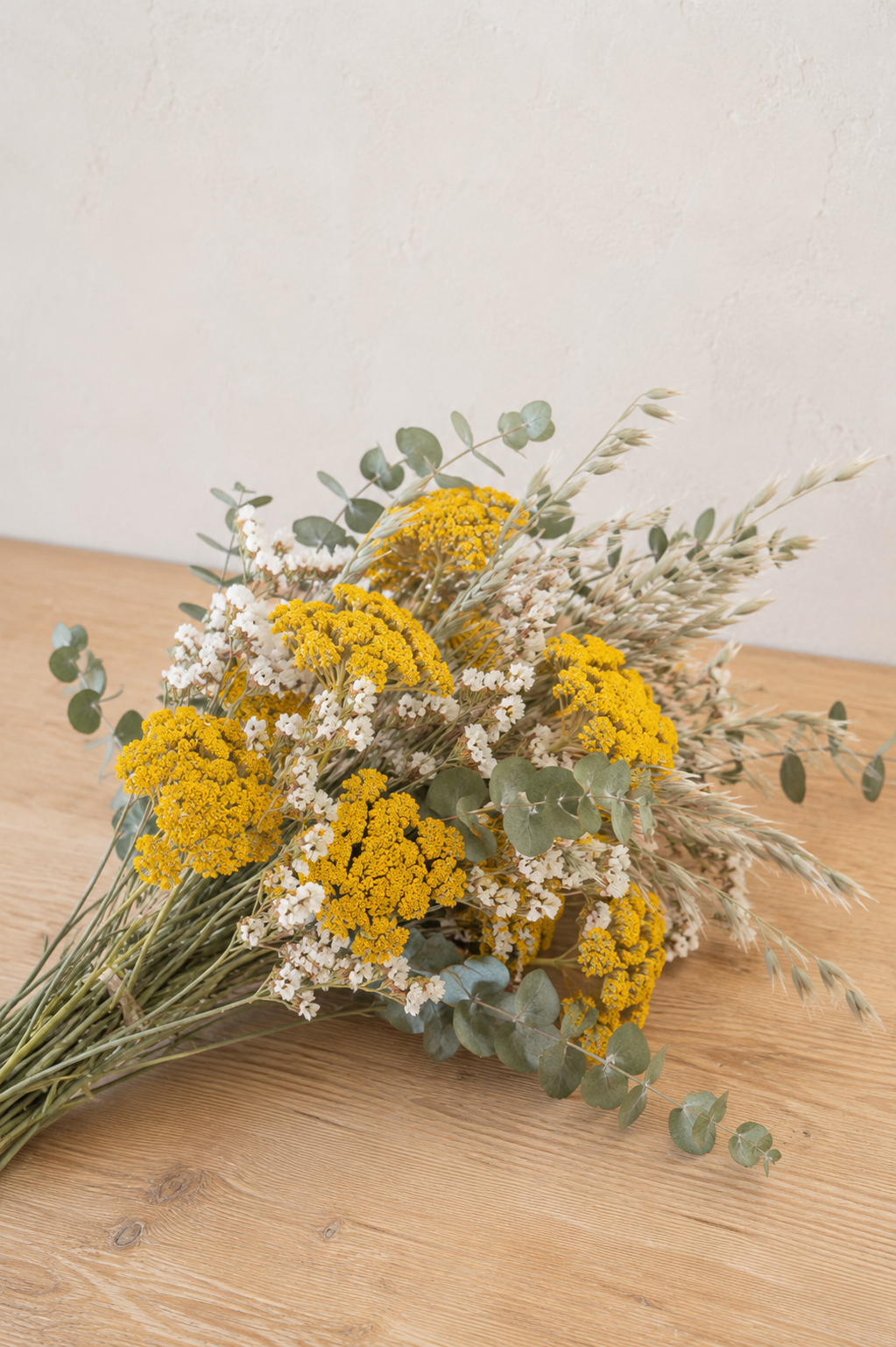 Bouquet de fleurs séchées composé d’achillée jaune, d’avoine naturelle, de statice blanc et d’eucalyptus, cultivés et séchés à la ferme florale bio Terralya dans le Gers.