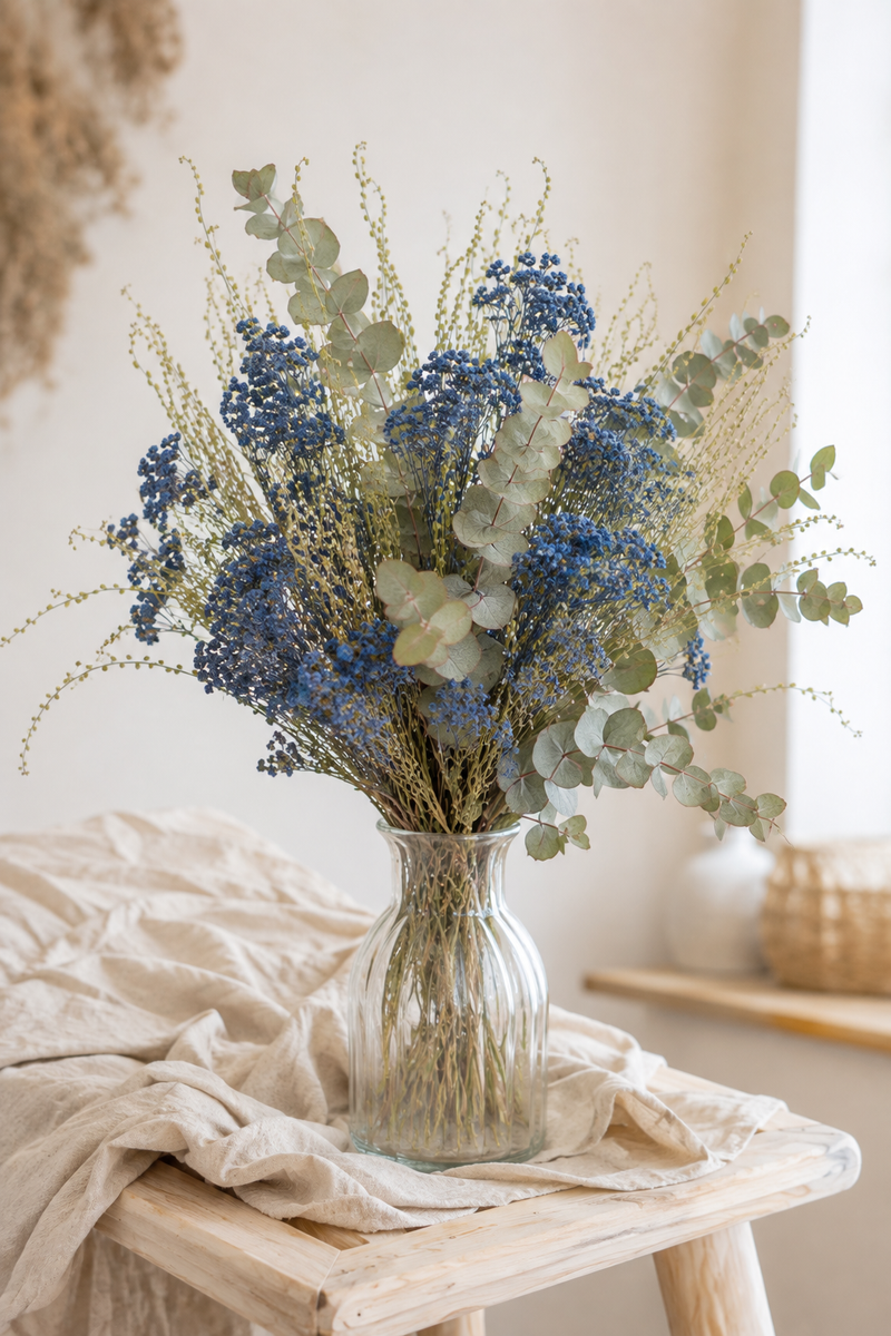 Bouquet de fleurs séchées composé d’achillée bleue, d’eucalyptus et de cresson dans un vase.