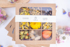 Coffret de têtes de fleurs séchées françaises bio Terralya dans les tons jaunes, présenté fermé avec son bandeau et ses neuf compartiments visibles.