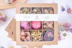 Coffret de têtes de fleurs séchées françaises bio Terralya, tons roses, présenté fermé avec son bandeau et ses neuf compartiments visibles.