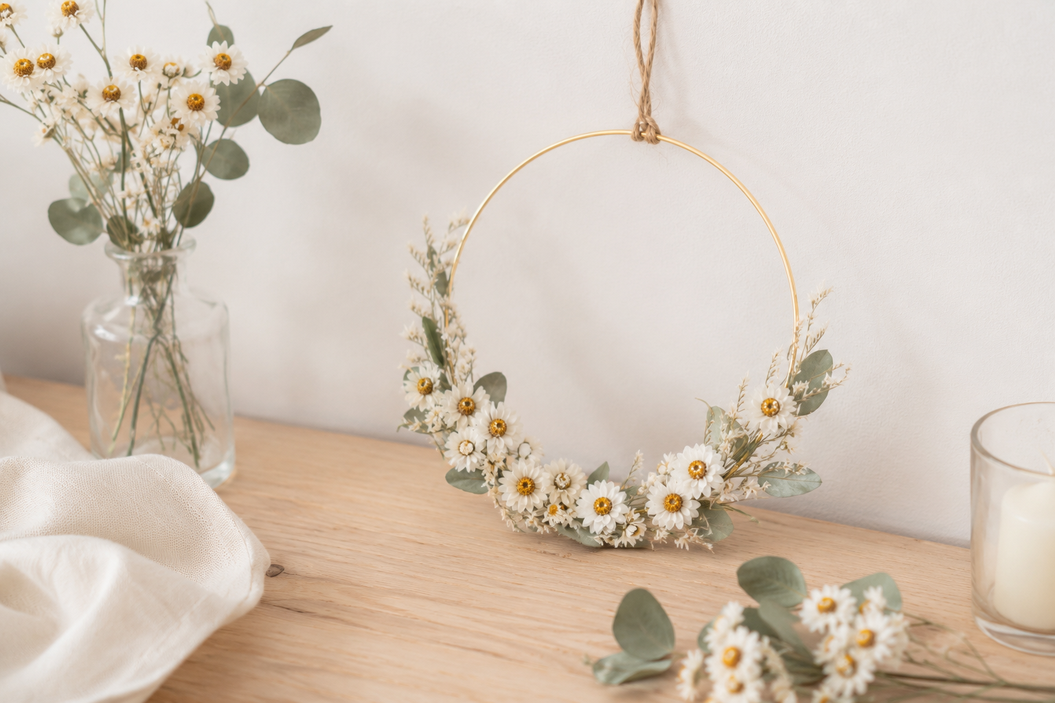 Couronne murale en fleurs séchées réalisée avec de l'ammobium blanc et de l'eucalyptus, idéale pour une décoration de mariage bohème ou une création DIY.